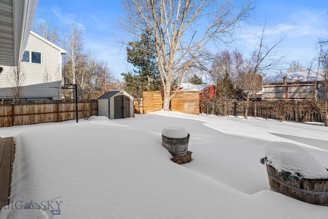 yard covered in snow with a storage unit