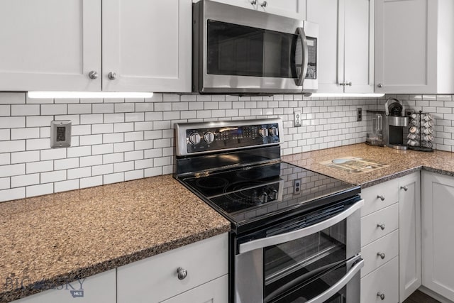 kitchen with stainless steel appliances, white cabinetry, and decorative backsplash