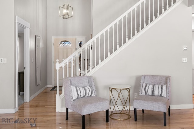 entryway with an inviting chandelier, hardwood / wood-style flooring, and a high ceiling