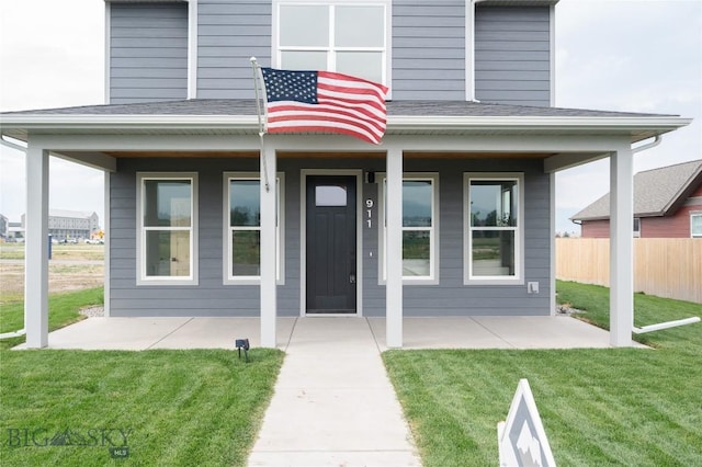 view of exterior entry featuring a yard and a patio area