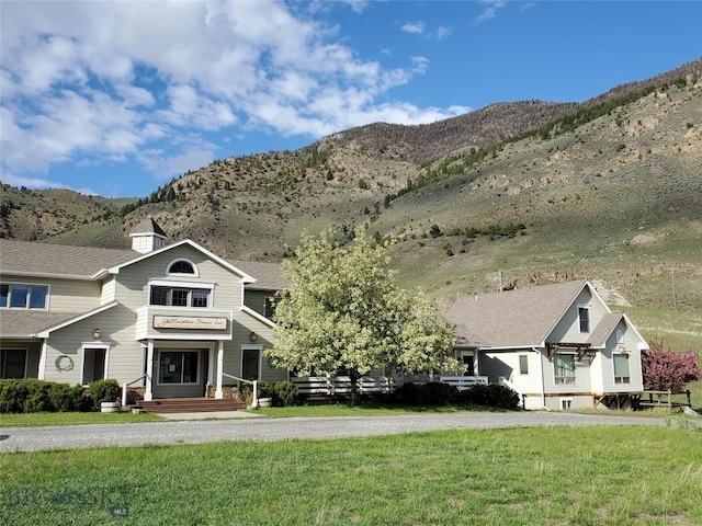 view of front facade featuring a mountain view and a front yard