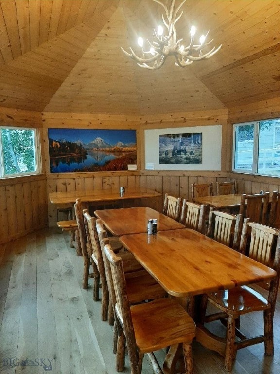 dining area featuring wood ceiling, wooden walls, and wood-type flooring