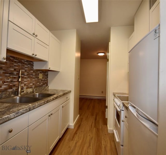 kitchen with white cabinetry, white range with electric cooktop, stainless steel fridge, and sink