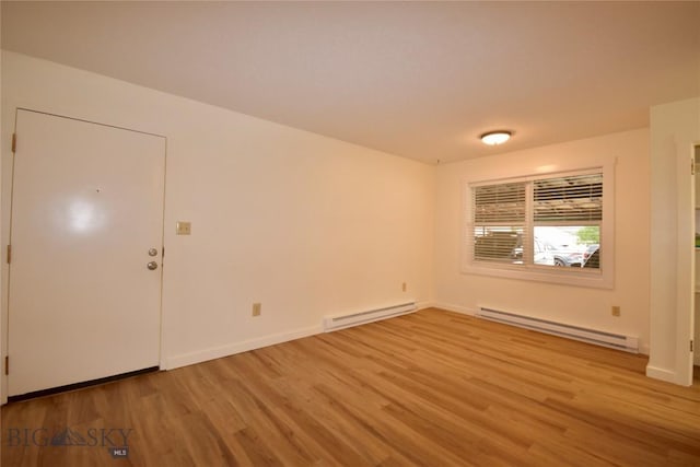 empty room featuring light hardwood / wood-style floors and baseboard heating