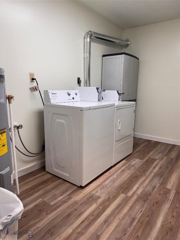 laundry room featuring electric water heater, dark hardwood / wood-style flooring, and washing machine and dryer