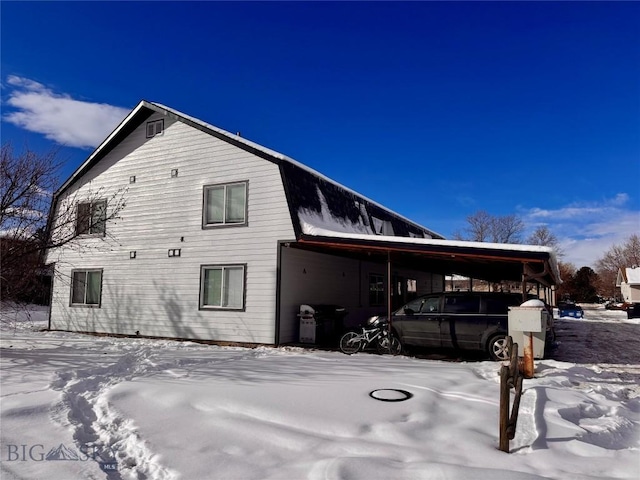 view of snow covered exterior with a carport