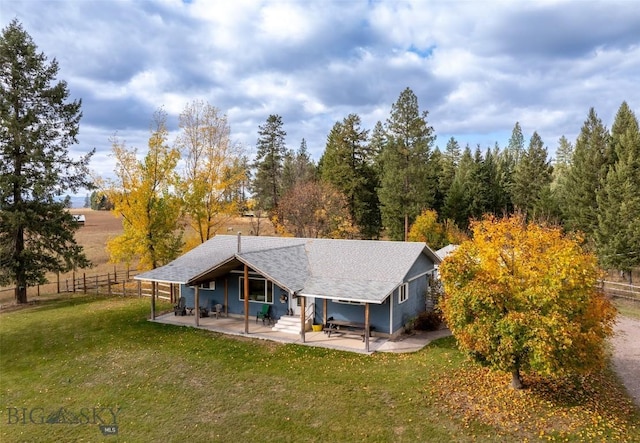 rear view of property featuring a patio area and a lawn