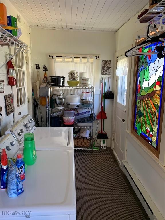 clothes washing area featuring a baseboard radiator, washer and dryer, and wooden ceiling