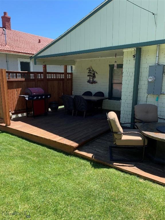 wooden terrace with area for grilling and a yard