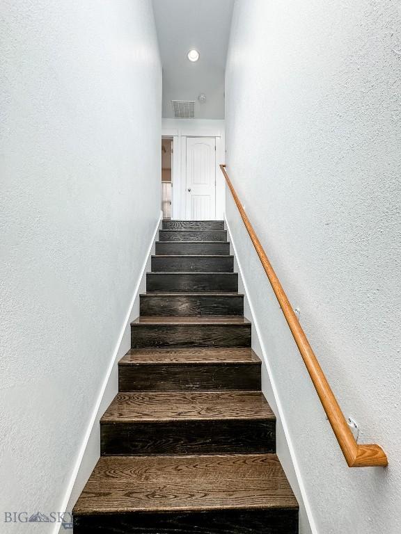 staircase with hardwood / wood-style floors