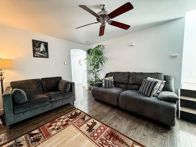 living room featuring ceiling fan and dark hardwood / wood-style floors