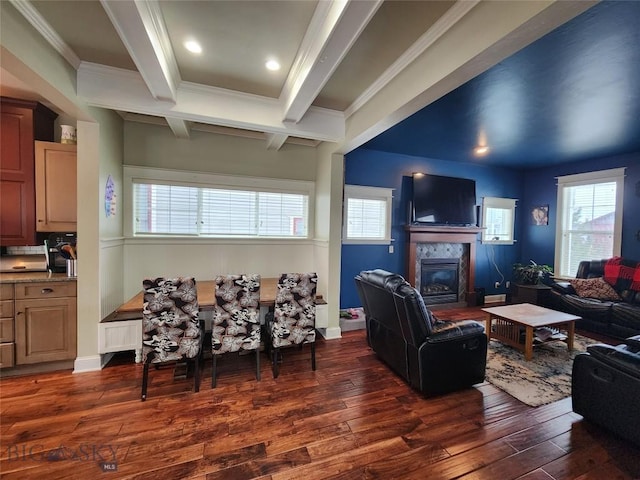 living room with beamed ceiling, a tile fireplace, dark wood-type flooring, and crown molding