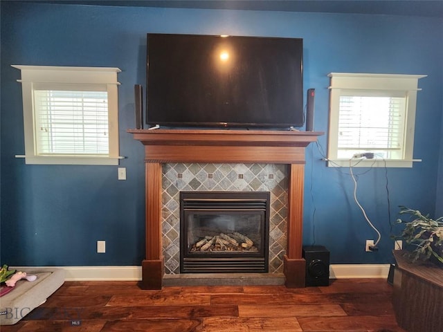 interior details with a tiled fireplace and hardwood / wood-style floors