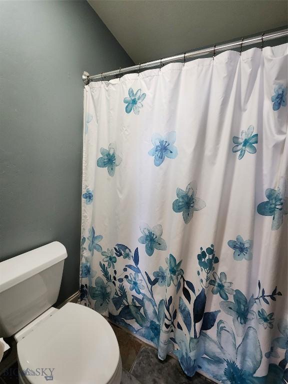 bathroom featuring a shower with curtain and toilet