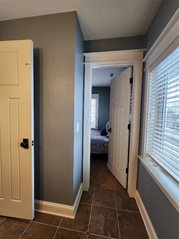 hallway with dark tile patterned flooring