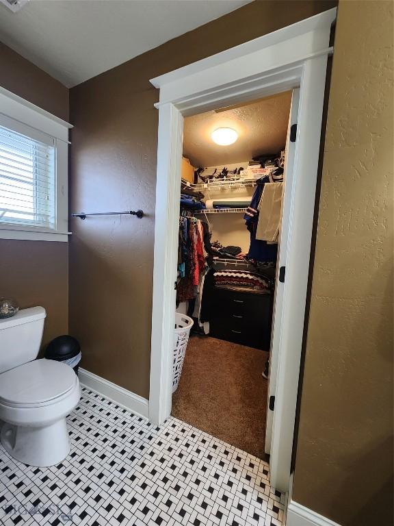 bathroom featuring toilet and tile patterned flooring