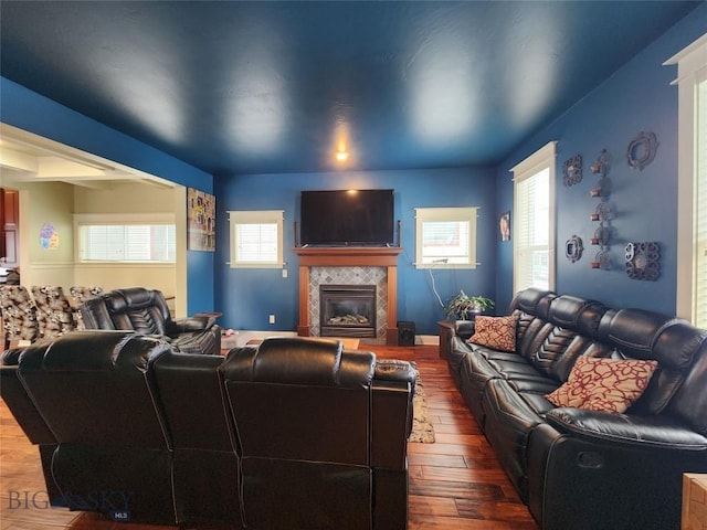 living room featuring a tiled fireplace and hardwood / wood-style flooring