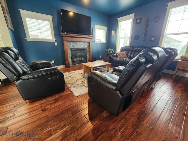 living room with dark hardwood / wood-style flooring and a tile fireplace