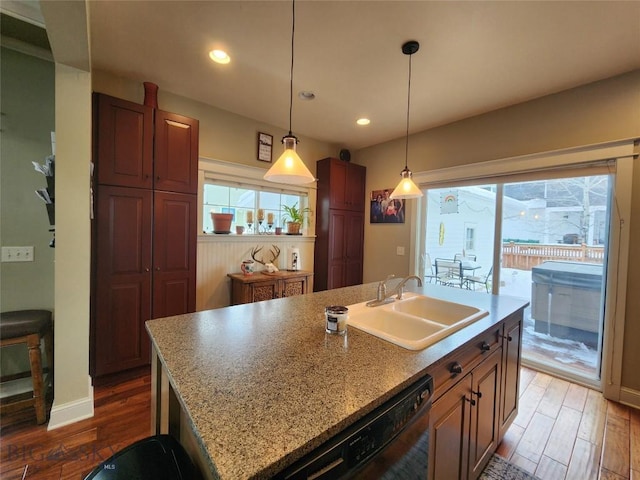 kitchen featuring sink, dark hardwood / wood-style flooring, dishwasher, an island with sink, and pendant lighting