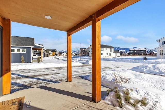 snow covered patio featuring a residential view