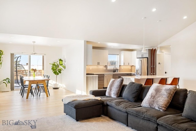 living area with recessed lighting, baseboards, and light wood-type flooring