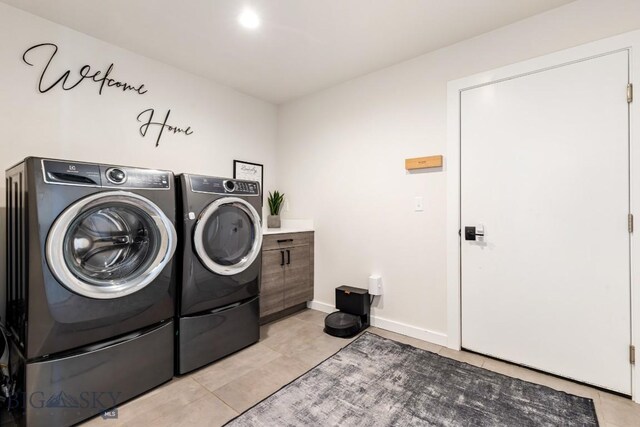 laundry room featuring washer and dryer, laundry area, baseboards, and light tile patterned floors
