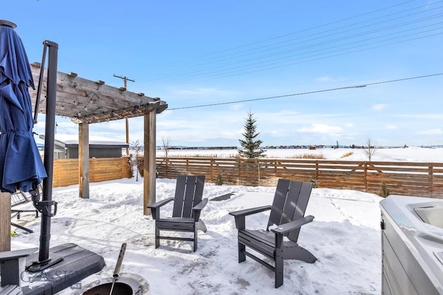 snow covered patio featuring a pergola and an outdoor fire pit