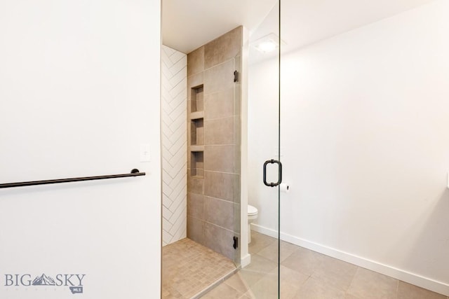 bathroom with baseboards, tile patterned floors, a stall shower, and toilet