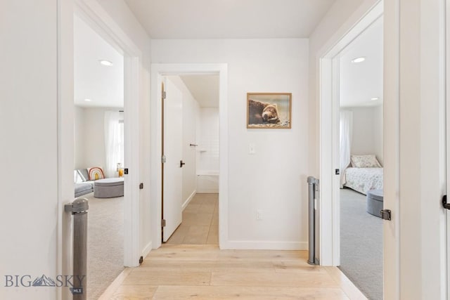 hall with recessed lighting, baseboards, light carpet, and light wood finished floors