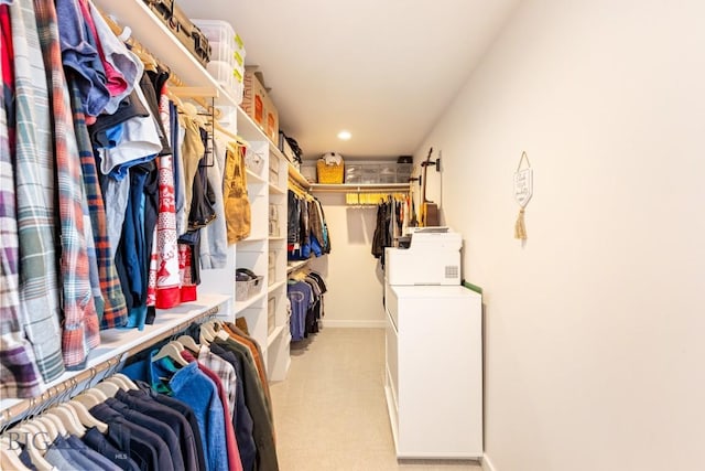 walk in closet featuring light carpet