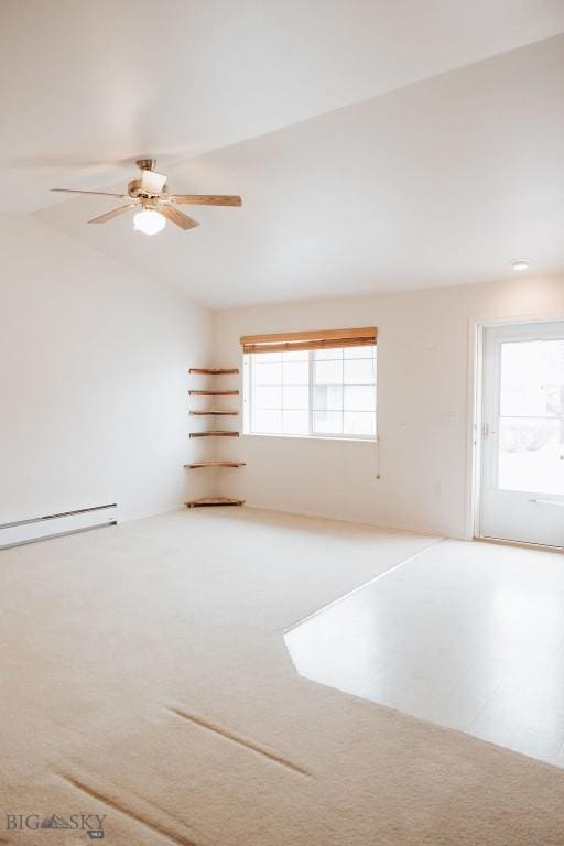 spare room with vaulted ceiling, baseboard heating, carpet floors, and a wealth of natural light