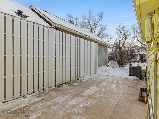 snow covered patio with central air condition unit