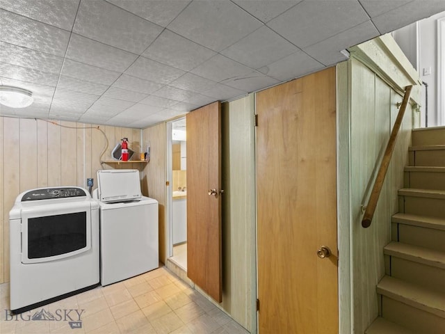 laundry area featuring washer and dryer and wooden walls