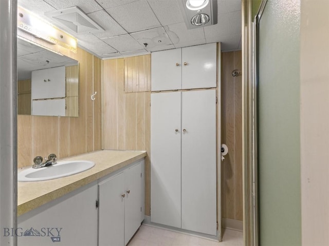 bathroom with vanity and wooden walls