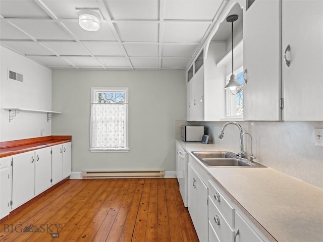 kitchen with sink, white cabinetry, a baseboard radiator, white dishwasher, and hardwood / wood-style floors