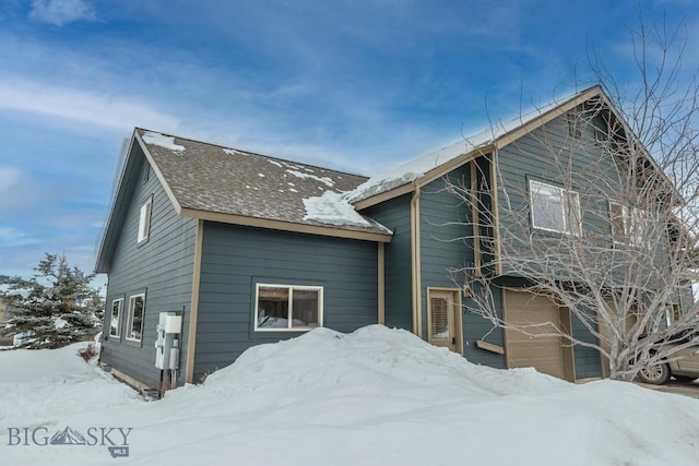 view of snow covered exterior with a garage