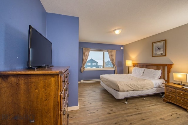 bedroom featuring hardwood / wood-style flooring and a baseboard radiator