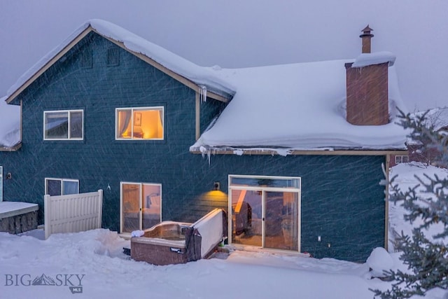 view of snow covered back of property