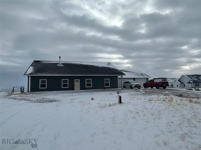 view of snow covered rear of property