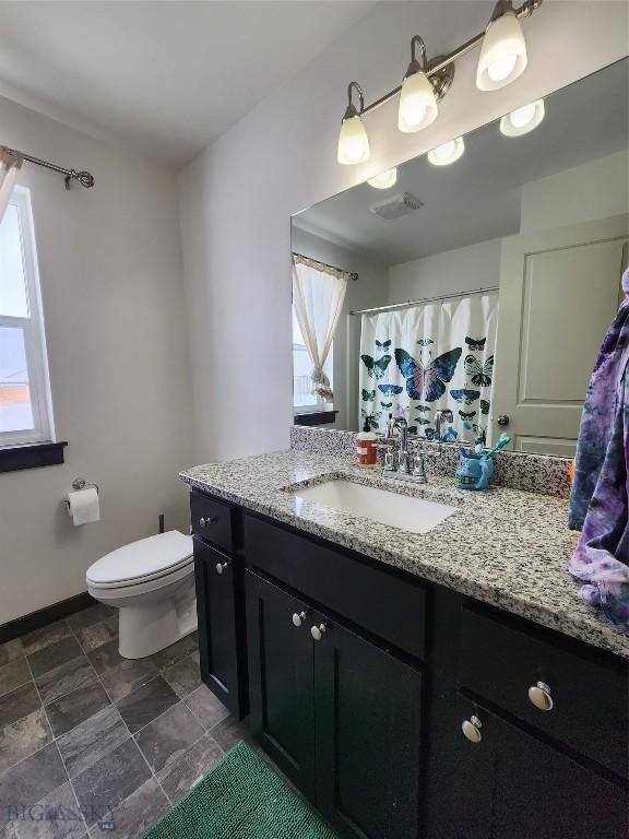 bathroom featuring vanity, toilet, baseboards, and visible vents