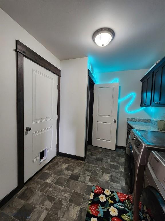 laundry room with visible vents, washer and dryer, stone finish flooring, cabinet space, and baseboards