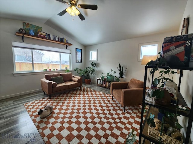 living room with vaulted ceiling, wood finished floors, baseboards, and ceiling fan