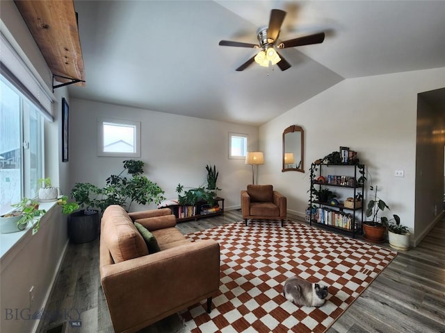 living area featuring ceiling fan, baseboards, wood finished floors, and vaulted ceiling