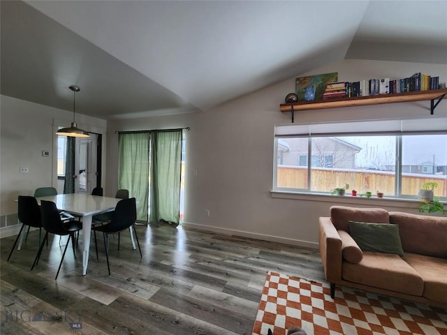 dining area featuring a wealth of natural light, lofted ceiling, and wood finished floors