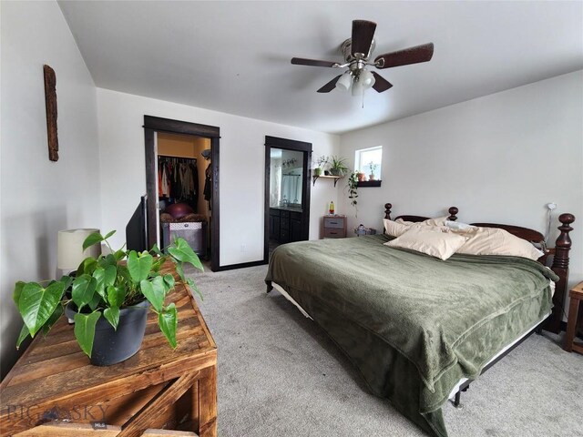 bedroom with light carpet, ceiling fan, a walk in closet, and a closet