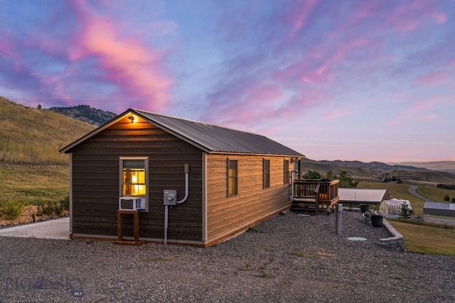 property exterior at dusk featuring a mountain view