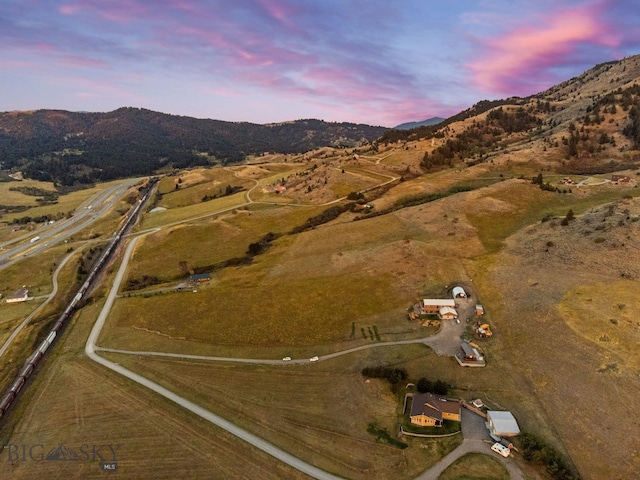 aerial view at dusk with a mountain view and a rural view