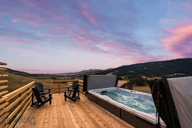 deck at dusk featuring a mountain view