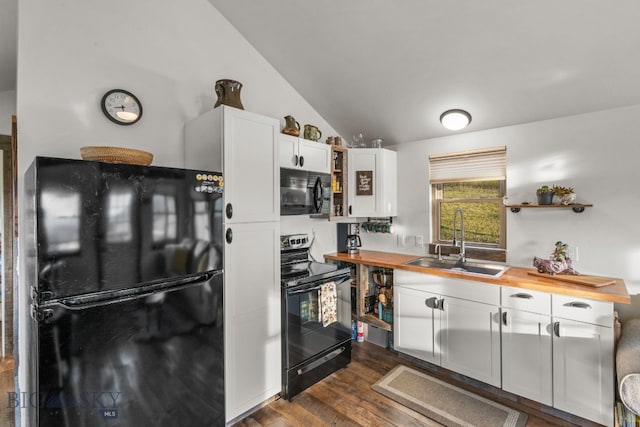 kitchen with lofted ceiling, sink, white cabinetry, black appliances, and wood counters