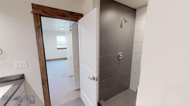 bathroom with vanity and a tile shower